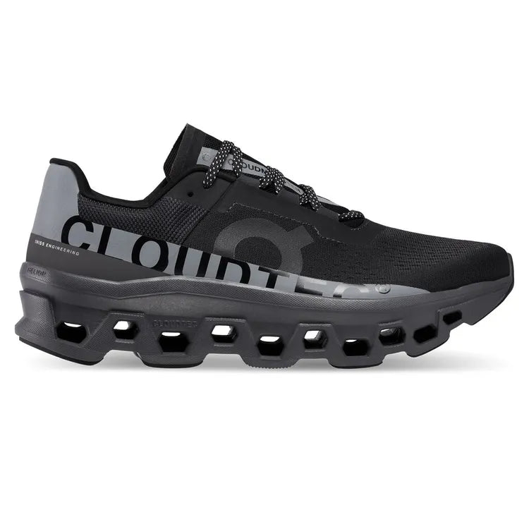 Side view on white background of Womens On Cloudmonster Lumos running shoe in Black, Medium (Regular) width
