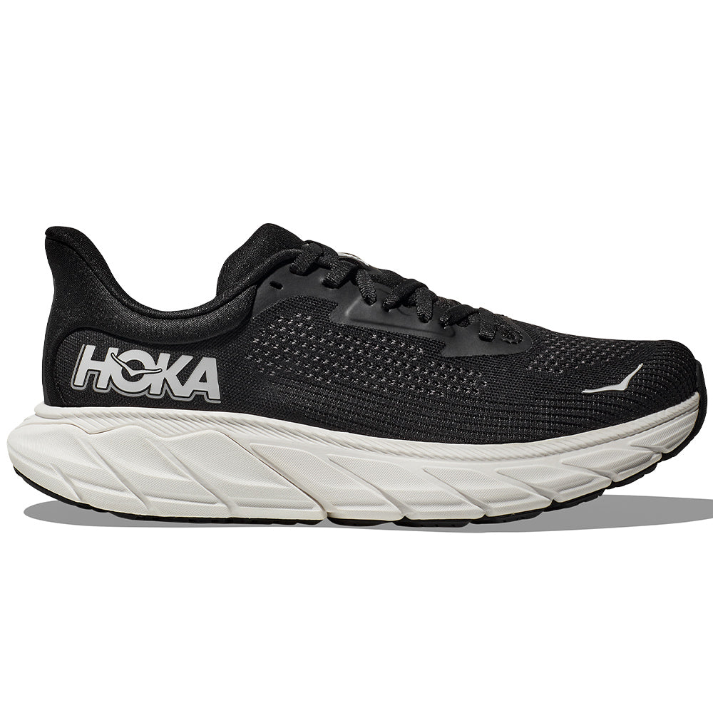 Side view on white background of Womens Hoka Arahi running shoe in Black/White, Medium (Regular) width