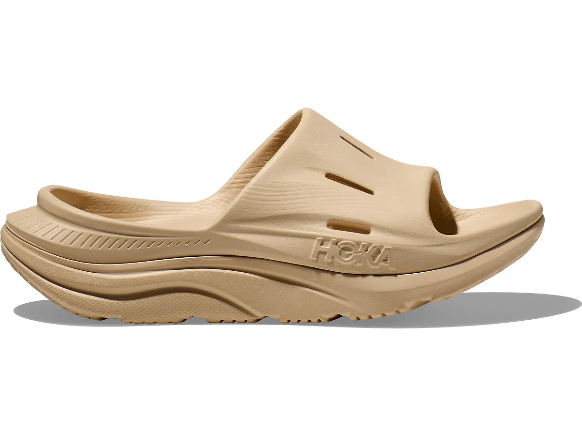 Side view on white background of Womens Hoka Ora Recovery Slide 3 running shoe in Shifting Sand, Medium (Regular) width
