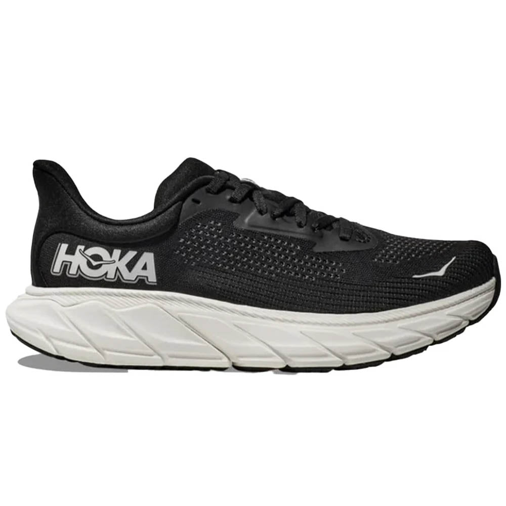 Side view on white background of Mens Hoka Arahi running shoe in Black/White, Medium (Regular) width