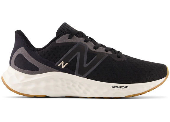 Side view on white background of Womens New Balance Fresh Foam Arishi v4 running shoe in Black/Light Gold Metallic/Gum, Medium (Regular) width