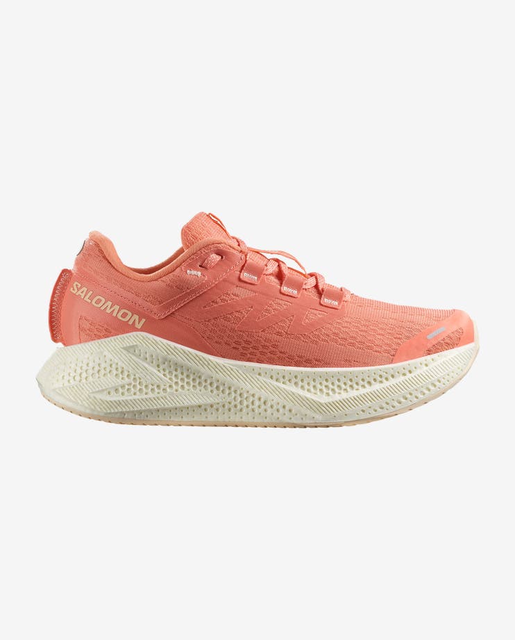 Side view on white background of Womens Salomon Aero Glide 3 running shoe in Fusion Coral/Vanilla Ice/Tender Peach, Wide width