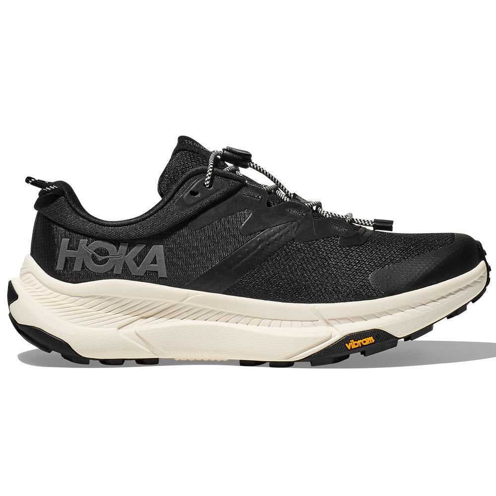 Side view on white background of Womens Hoka Transport running shoe in Black/Alabaster, Wide width